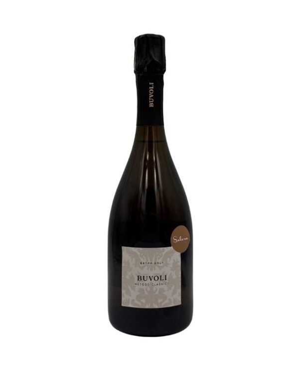 Bottiglia di spumante Buvoli Metodo Classico Extra Brut con etichetta beige chiaro con un motivo damascato e la scritta "BUVOLI METODO CLASSICO EXTRA BRUT". Sul collo è presente la scritta verticale "BUVOLI" e un piccolo adesivo rotondo marrone chiaro con la scritta "Solera.
